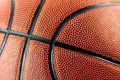 Detailed close-up texture of an orange basketball surface with black grip lines and realistic sports material pattern.